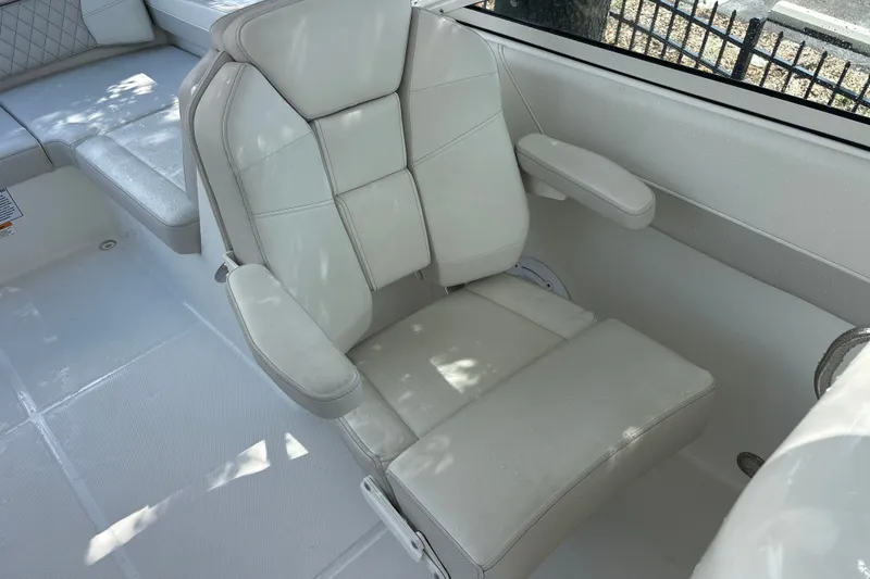 Slide: The Image of 2024 World Cat 230 SD boat interior with comfortable white seating and armrests. - 16