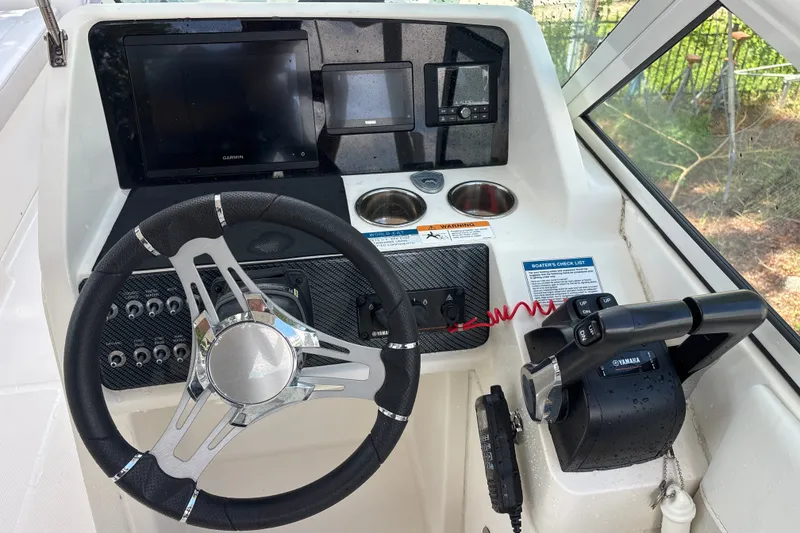 Slide: The Image of 2024 World Cat 230 SD helm with steering wheel, Garmin display, and Yamaha controls. - 5