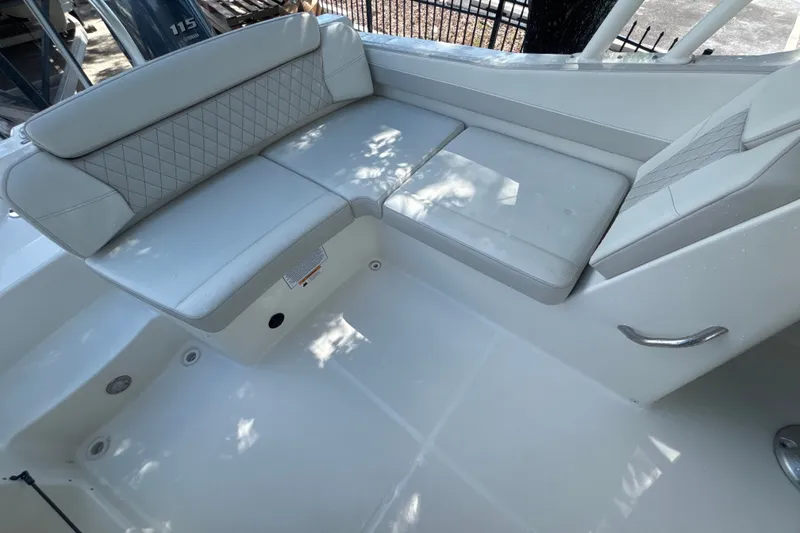 Slide: The Image of 2024 World Cat 230 SD boat interior with white cushioned seating. - 8