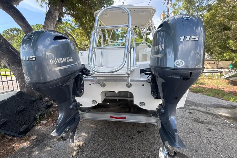 Slide: The Image of 2024 World Cat 230 SD boat with dual Yamaha 115 outboard engines, parked outdoors. - 4