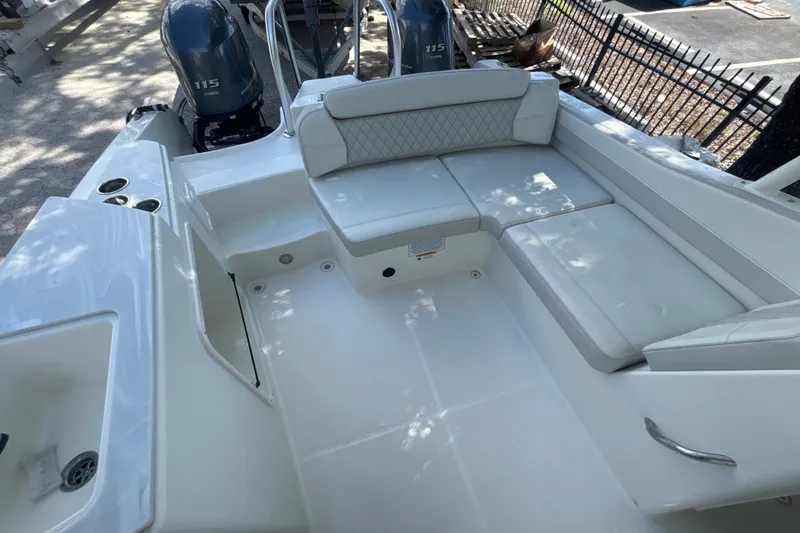 Slide: The Image of 2024 World Cat 230 SD boat interior with cushioned seating and dual 115 engines. - 6