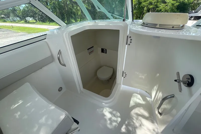 Slide: The Image of 2024 World Cat 230 SD boat interior with compact marine toilet. - 18