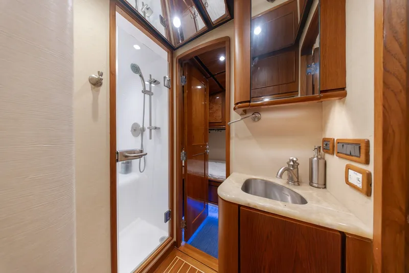 Slide: The Image of Luxurious yacht bathroom with wooden cabinetry, shower, and modern fixtures in a 2010 Jamie Chadwick 61' Convertible. - 87