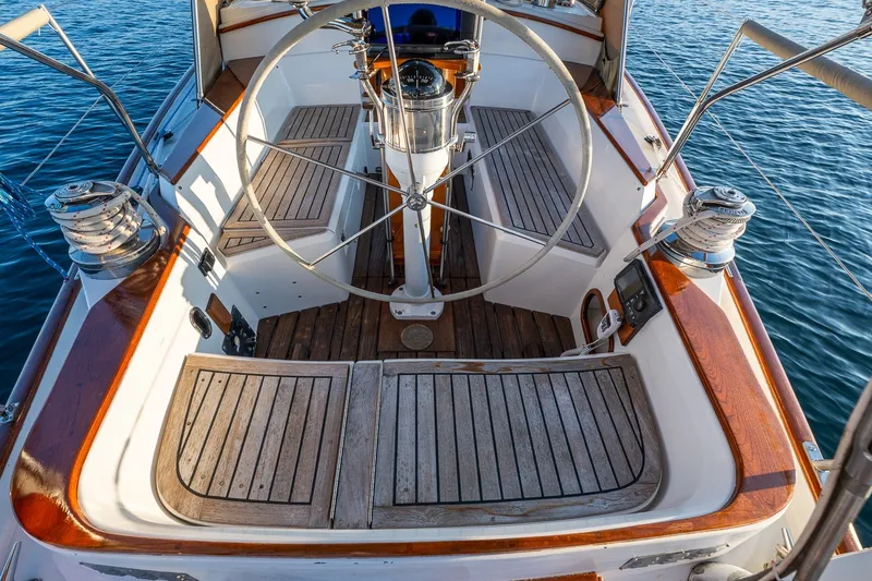 Slide: The Image of Cockpit of 1990 Able 42 sailboat with wooden deck and steering wheel on calm water. - 19