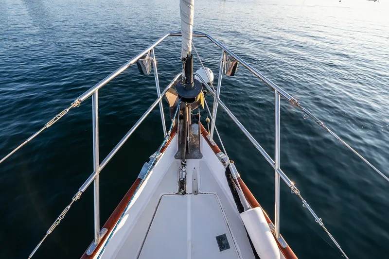 Slide: The Image of Bow of 1990 Able 42 sailboat on calm water, showcasing deck and railing. - 9