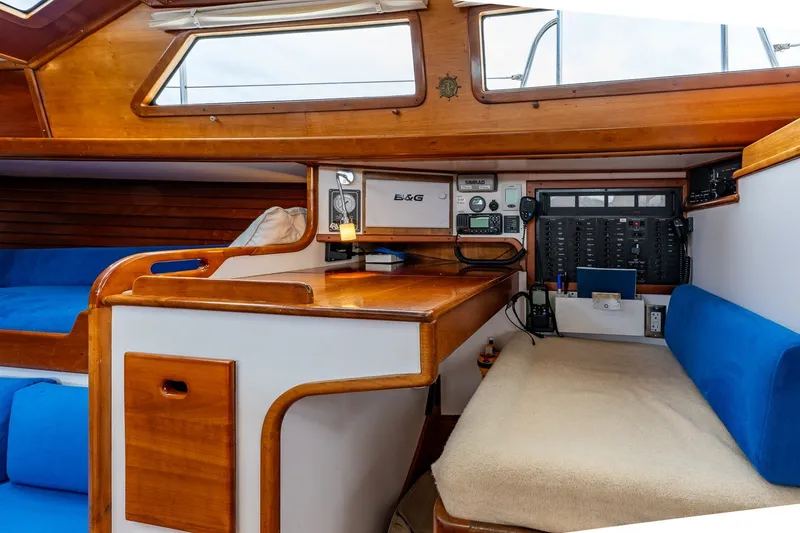 Slide: The Image of Interior of a 1990 Able 42 sailboat featuring navigation equipment and cozy seating. - 28