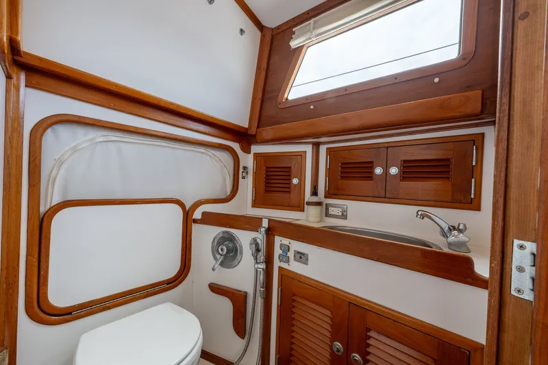 Slide: The Image of 1990 Able 42 yacht bathroom with wooden cabinetry, sink, and toilet. - 30