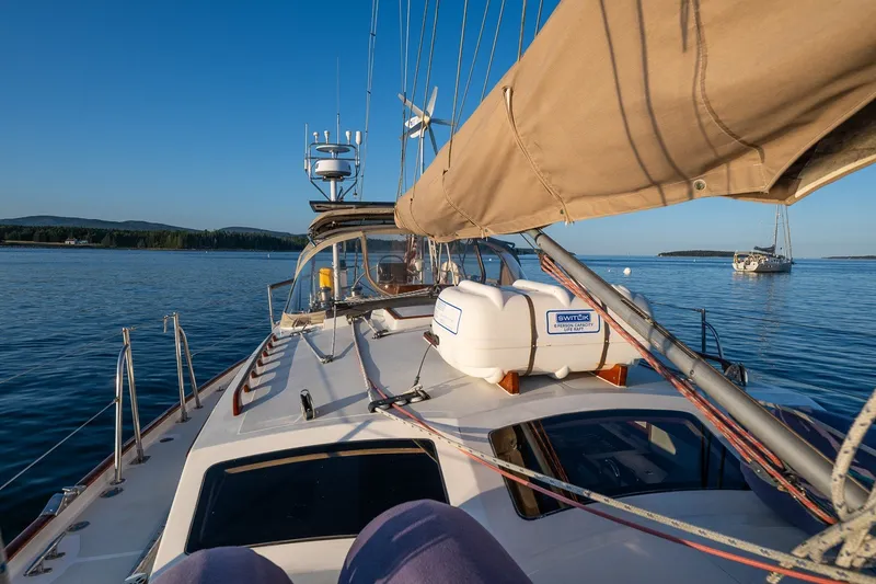Slide: The Image of Sailboat on calm water, featuring Able 42 model from 1990, under clear blue sky. - 13