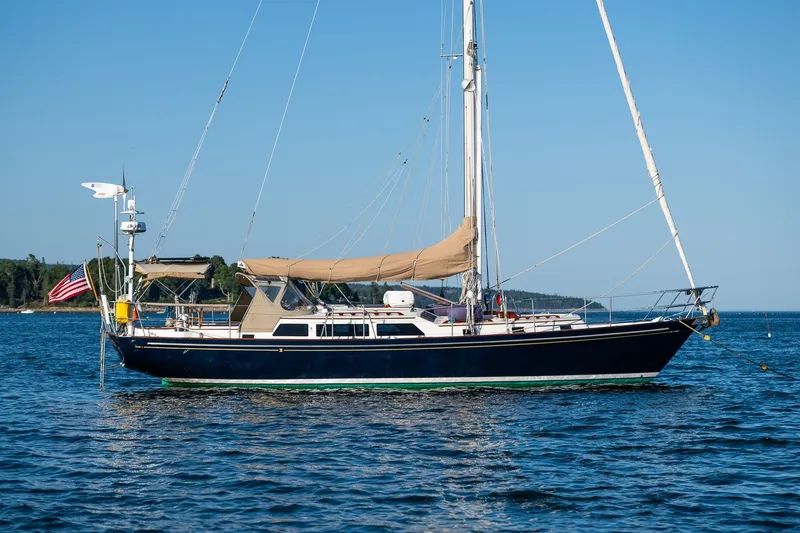 Slide: The Image of Sailboat on calm water, Able 42 model, 1990, with American flag, clear sky background. - 45
