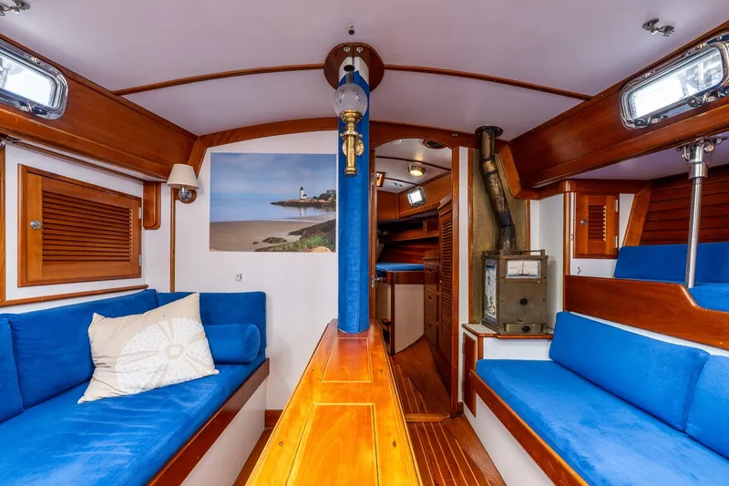 Slide: The Image of Cozy 1990 Able 42 yacht interior with blue seating, wooden accents, and nautical decor. - 33