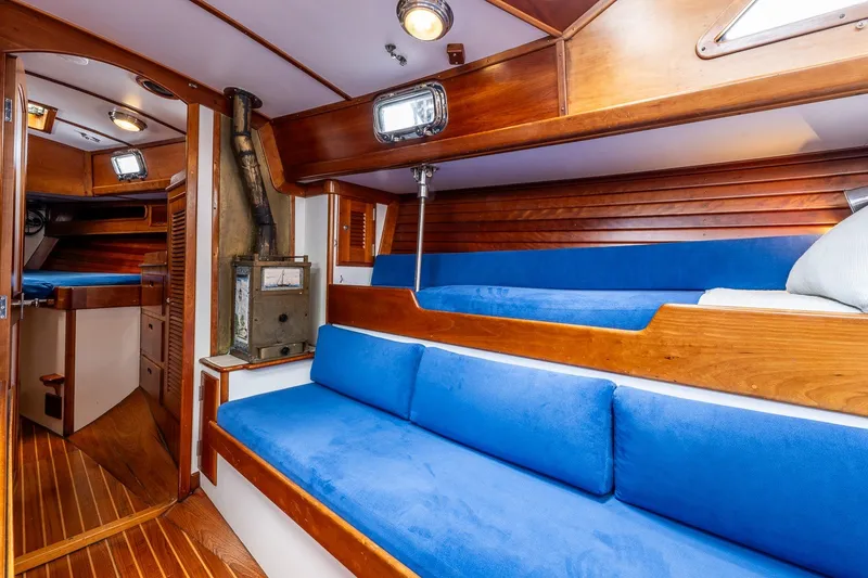 Slide: The Image of Interior of 1990 Able 42 sailboat with blue cushions and wooden finishes. - 35