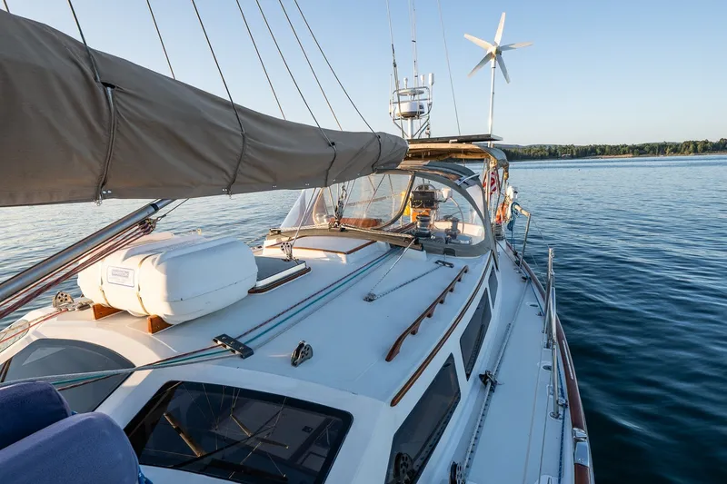 Slide: The Image of Sailboat on calm water, Able 42 model, 1990, with wind turbine and clear sky. - 12