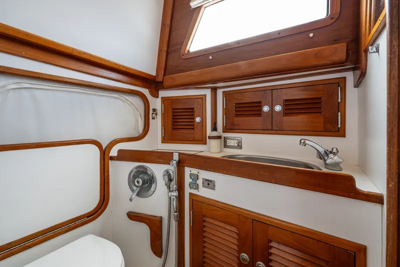 Slide: The Image of 1990 Able 42 yacht bathroom with wooden cabinets, sink, and nautical fixtures. - 32