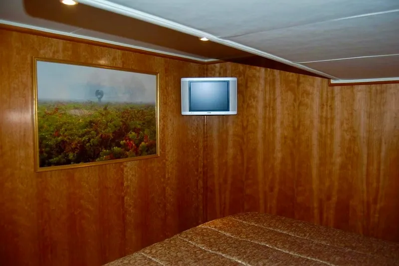 Slide: The Image of Wood-paneled cabin interior of 2007 Navigator 44 Classic yacht with TV and framed artwork. - 27