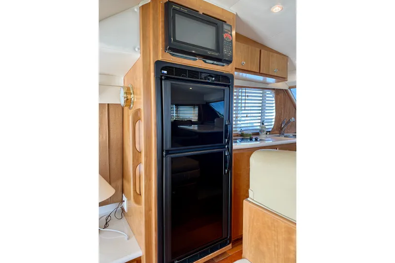 Slide: The Image of 2007 Navigator 44 Classic yacht interior with fridge, microwave, and wooden cabinetry. - 23