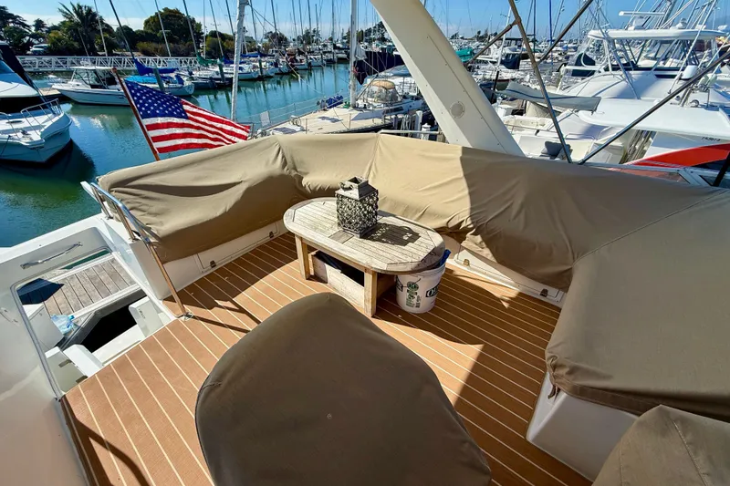 Slide: The Image of Luxurious 2007 Navigator 44 Classic yacht deck with seating, table, and American flag. - 45