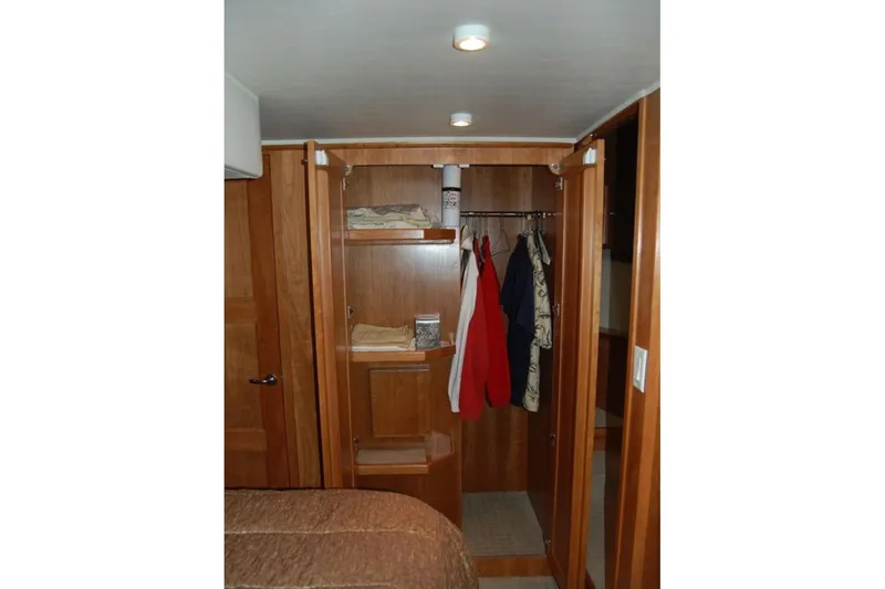 Slide: The Image of Wooden closet interior on 2007 Navigator 44 Classic yacht, featuring hanging clothes and shelves. - 25