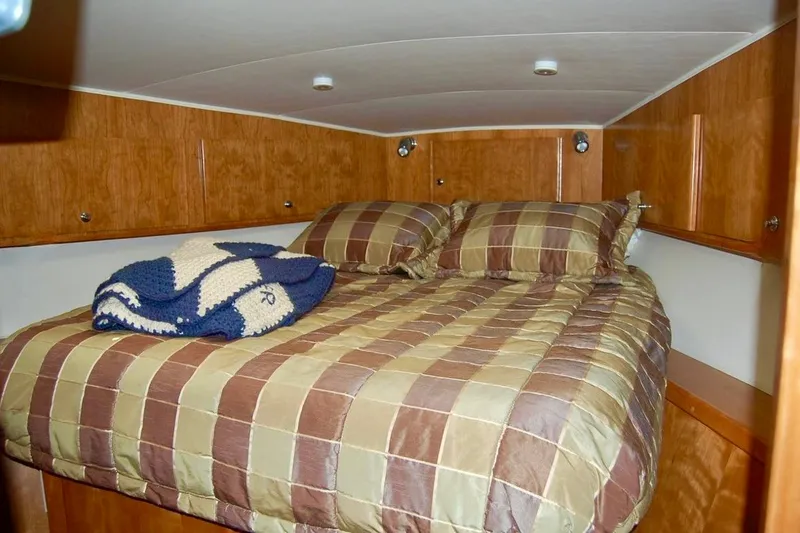 Slide: The Image of Cozy cabin bedroom in 2007 Navigator 44 Classic yacht with plaid bedding and wooden cabinetry. - 33