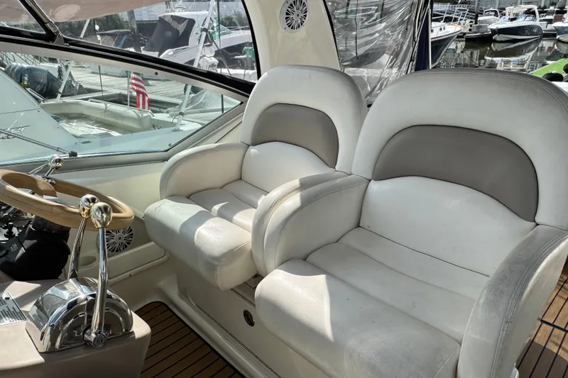 Slide: The Image of 2005 Sea Ray 340 Sundancer cockpit with dual seats and wooden steering wheel. - 9