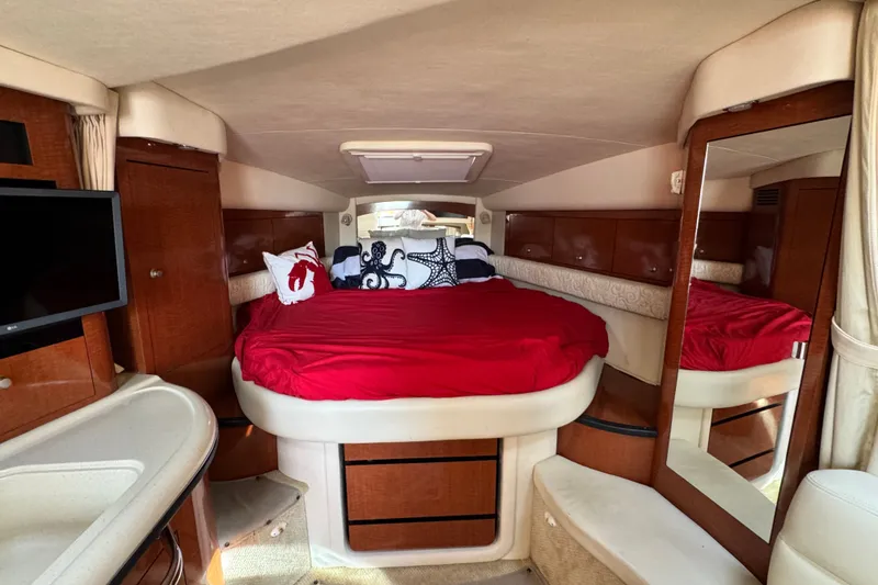 Slide: The Image of Luxurious interior of 2005 Sea Ray 340 Sundancer with red bedding and nautical decor. - 15
