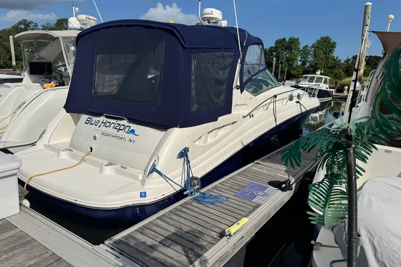 The Image of 2005 Sea Ray 340 Sundancer docked, featuring a blue canopy and "Blue Horizon" name. - 0