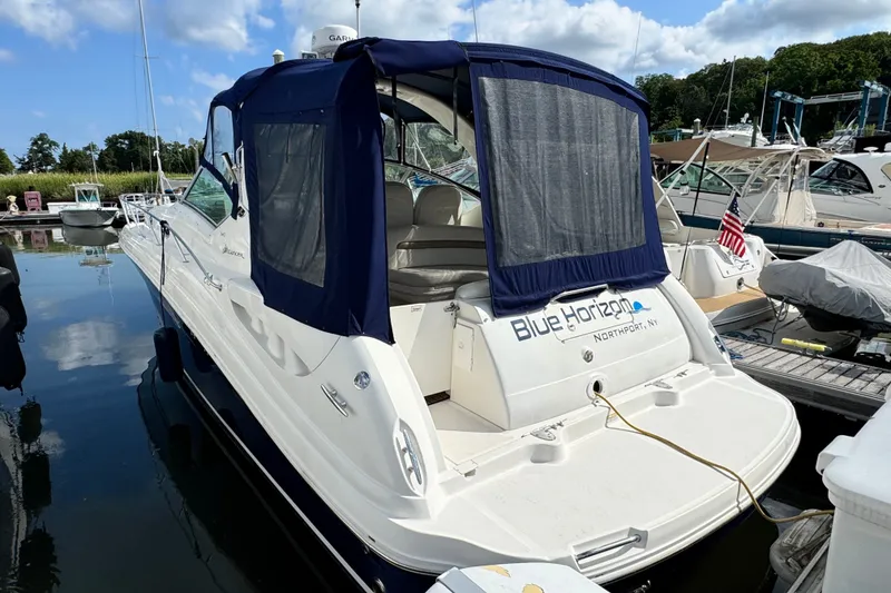 Slide: The Image of 2005 Sea Ray 340 Sundancer docked, featuring blue canopy and sleek design. - 4