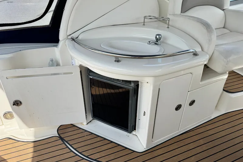 Slide: The Image of 2005 Sea Ray 340 Sundancer boat interior with sink, mini fridge, and seating area. - 12