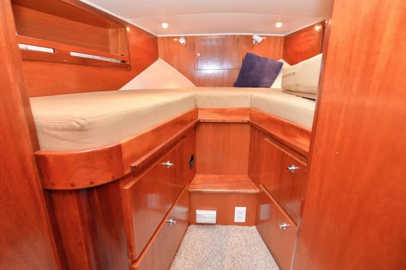 Slide: The Image of Cozy cabin interior of 2006 Navigator 34 Californian yacht with wooden finish and cushioned bed. - 26