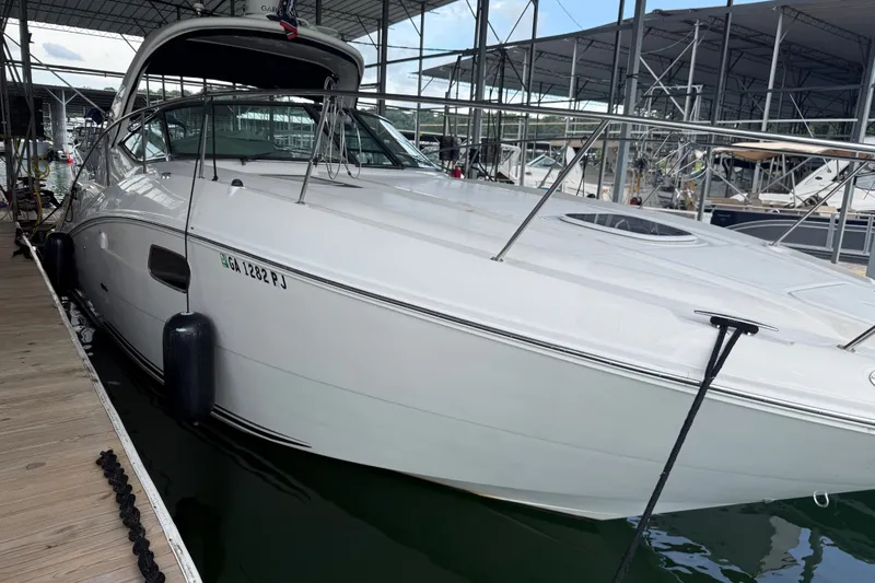 Slide: The Image of 2011 Sea Ray Sundancer 350 docked at marina, sleek white design, side view. - 5