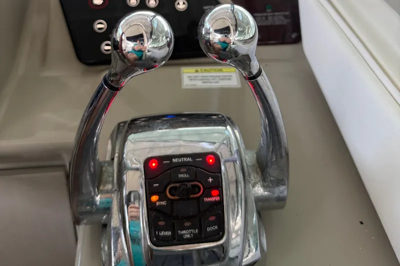 Slide: The Image of Throttle controls of a 2011 Sea Ray Sundancer 350 boat, featuring dual levers and control panel. - 10