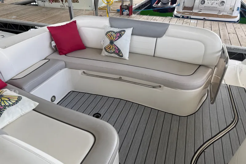 Slide: The Image of 2011 Sea Ray Sundancer 350 boat seating area with butterfly-themed pillows and striped flooring. - 14