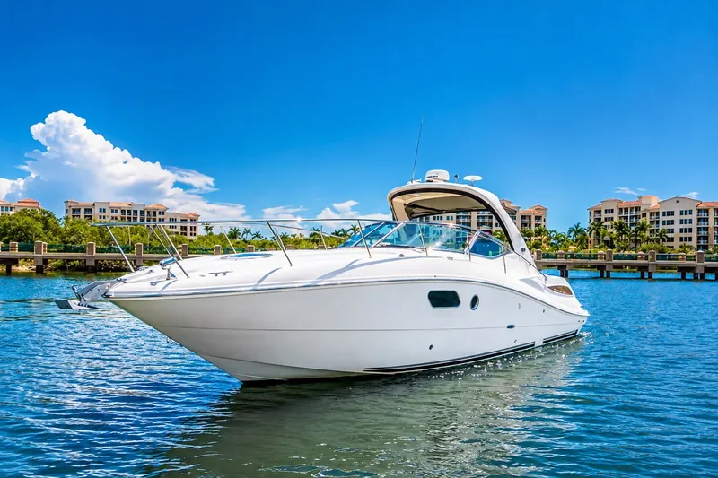 The Image of 2011 Sea Ray Sundancer 350 yacht cruising on a sunny day near waterfront buildings. - 0