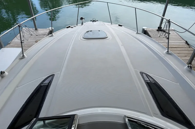 Slide: The Image of 2011 Sea Ray Sundancer 350 yacht docked, showcasing sleek deck design and waterfront view. - 15