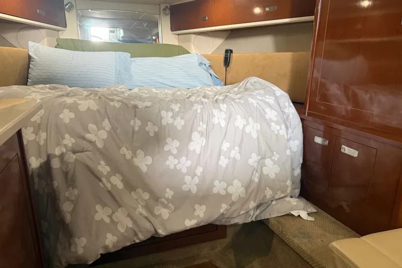 Slide: The Image of Cozy cabin interior of 2011 Sea Ray Sundancer 350 with floral bedding and wooden cabinetry. - 17