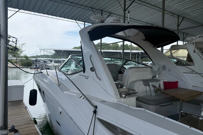 Slide: The Image of 2011 Sea Ray Sundancer 350 docked in a covered marina, showcasing sleek design and comfortable seating. - 6