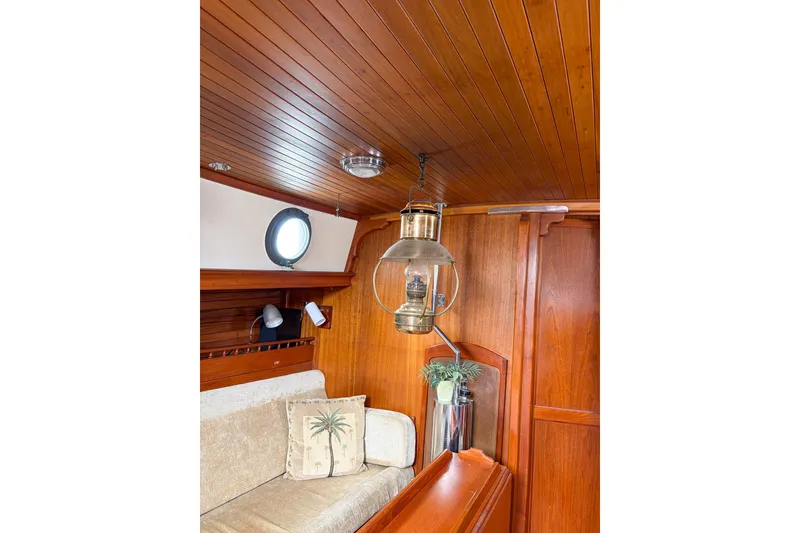Slide: The Image of Cozy 1973 Westsail 32 yacht interior with wooden paneling and vintage lantern. - 9