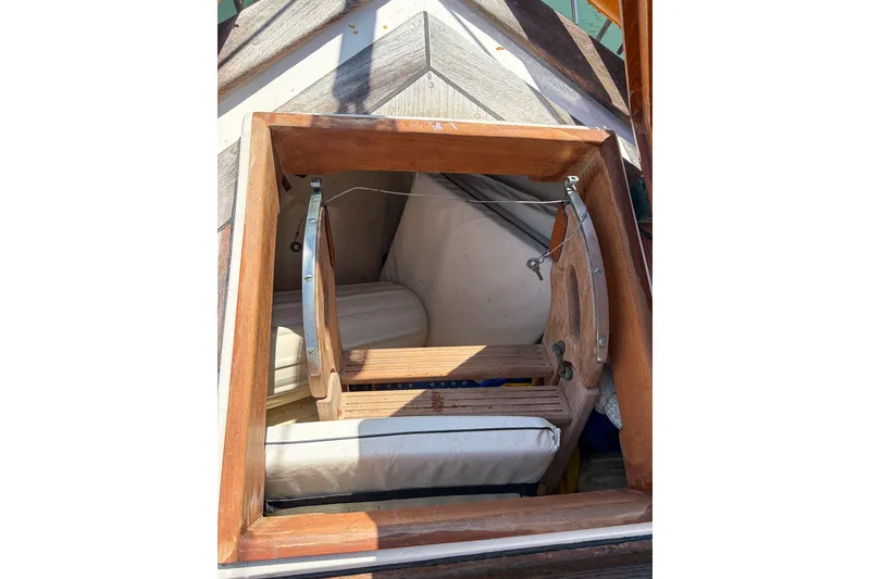 Slide: The Image of 1973 Westsail 32 sailboat cabin entrance with wooden frame and cushions. - 13