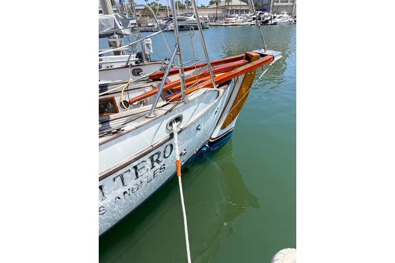 Slide: The Image of 1973 Westsail 32 sailboat docked in marina, featuring wooden accents and mooring line. - 8