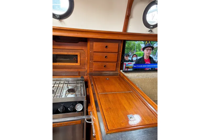 Slide: The Image of Interior of 1973 Westsail 32 sailboat with wooden cabinetry and stove. - 11