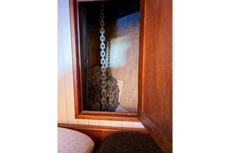 Slide: The Image of Anchor chain storage inside 1973 Westsail 32 sailboat, wooden interior detail. - 14