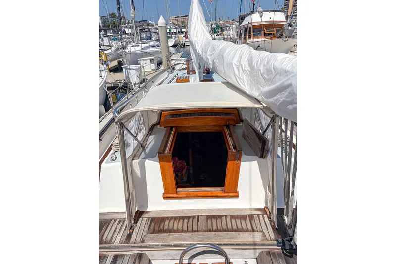 Slide: The Image of 1973 Westsail 32 sailboat deck with open cabin hatch in marina setting. - 2