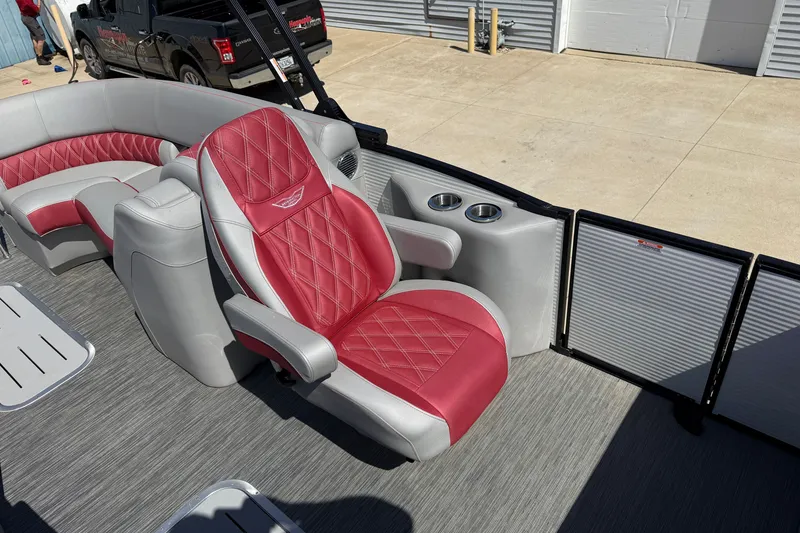 Slide: The Image of 2022 Bennington R 24 Quad Bench Bowrider with red and gray seating, docked outdoors. - 15
