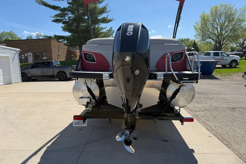 Slide: The Image of 2022 Bennington R 24 Quad Bench Bowrider with powerful outboard motor, parked outdoors. - 6