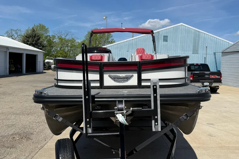 Slide: The Image of 2022 Bennington R 24 Quad Bench Bowrider on trailer, parked outdoors. - 2