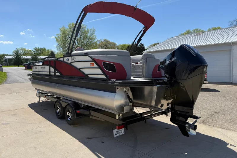 Slide: The Image of 2022 Bennington R 24 Quad Bench Bowrider pontoon boat on trailer, parked outdoors. - 5