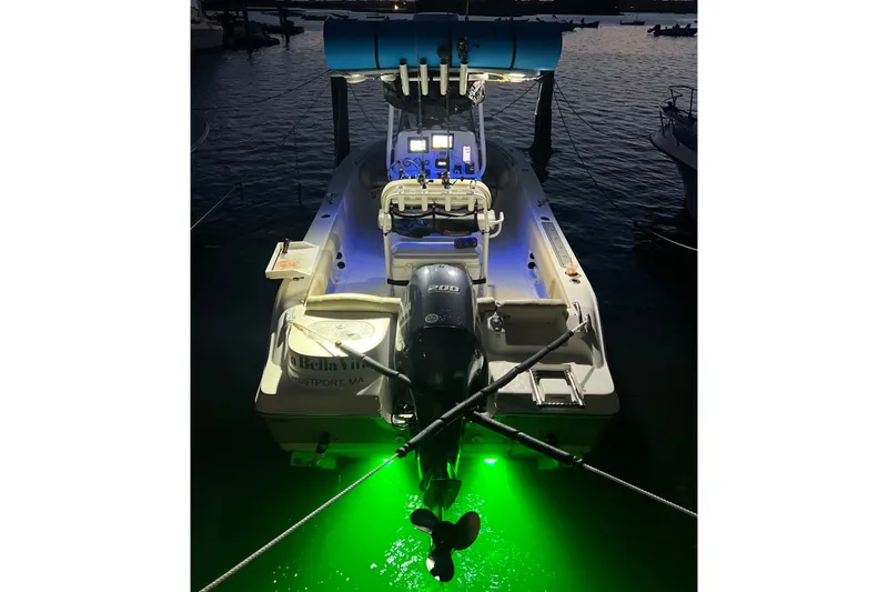 Slide: The Image of 2018 NauticStar 2302 Legacy boat with illuminated green underwater lights at dock. - 3