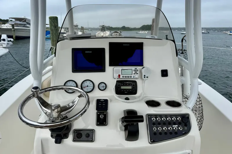 Slide: The Image of 2018 NauticStar 2302 Legacy boat dashboard with steering wheel and navigation controls. - 4