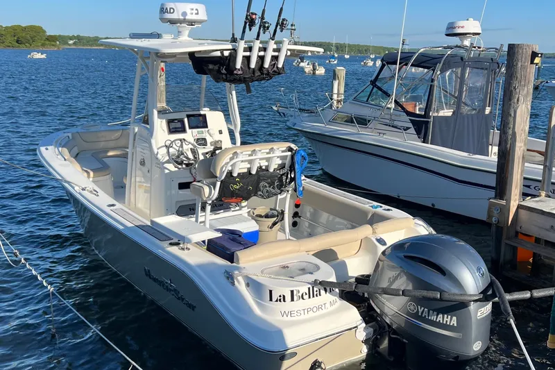 Slide: The Image of 2018 NauticStar 2302 Legacy boat docked with Yamaha engine, equipped for fishing. - 2