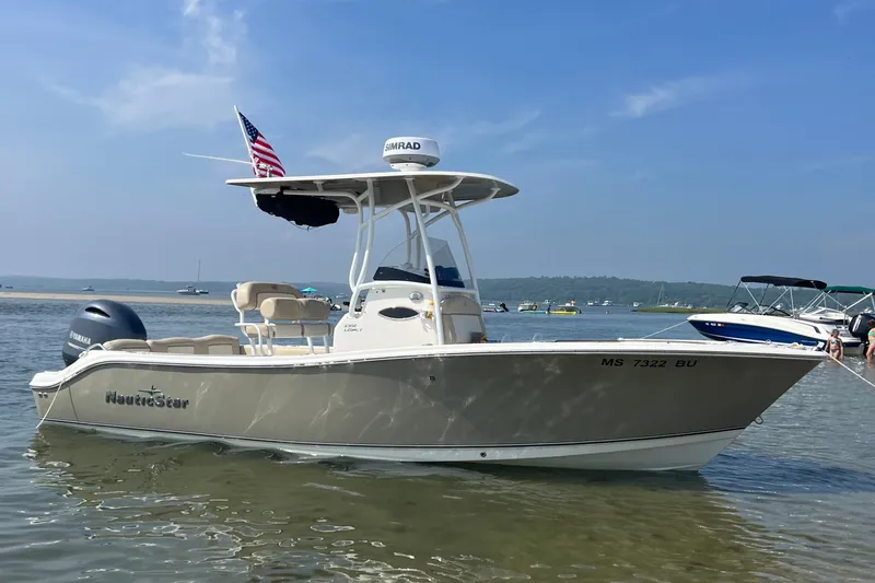 The Image of 2018 NauticStar 2302 Legacy boat anchored in shallow water with American flag. - 0