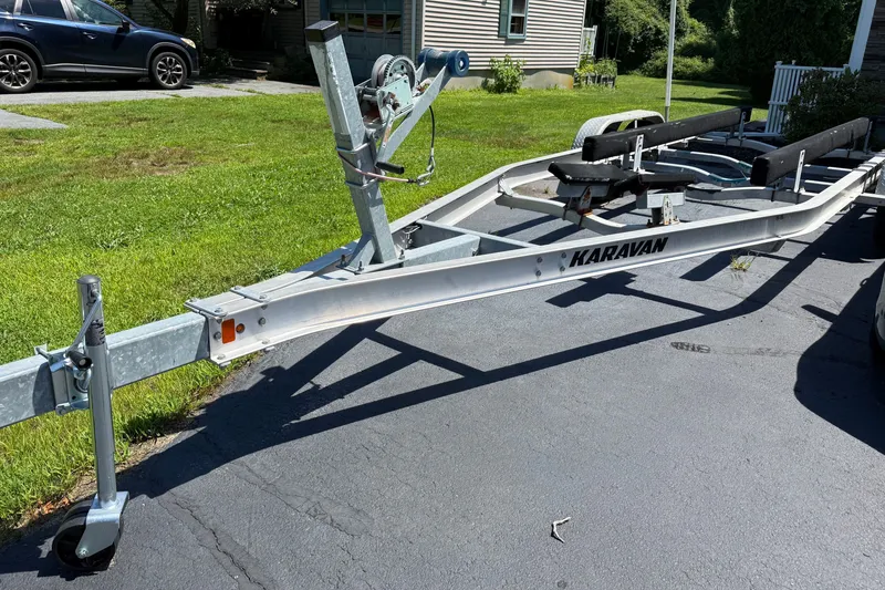 Slide: The Image of Boat trailer for 2018 NauticStar 2302 Legacy, parked on driveway, labeled "Karavan." - 6